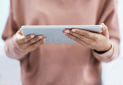 Buy stock photo Shot of an unrecognisable woman using a digital tablet at home