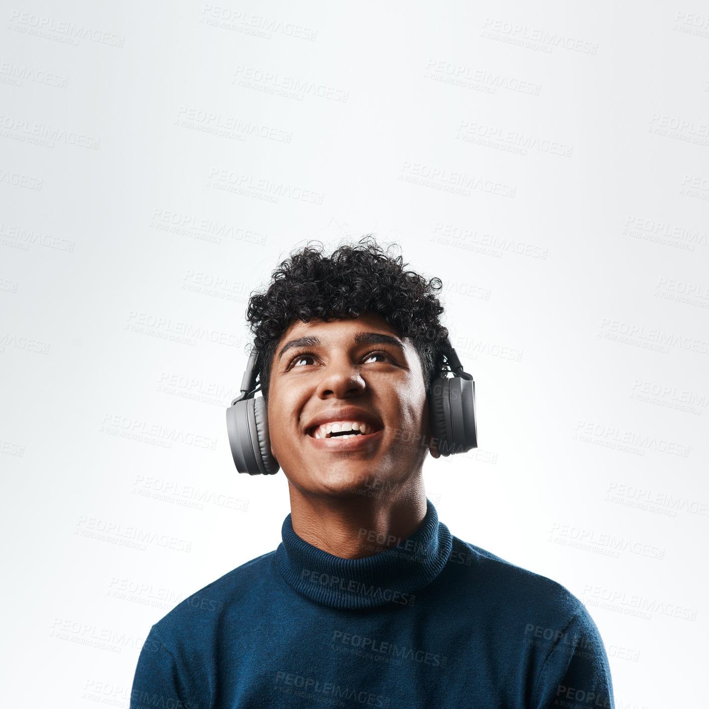 Buy stock photo Studio shot of a young man using headphones against a grey background