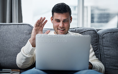 Buy stock photo Shot of a young man using a laptop to make a video call while working from home