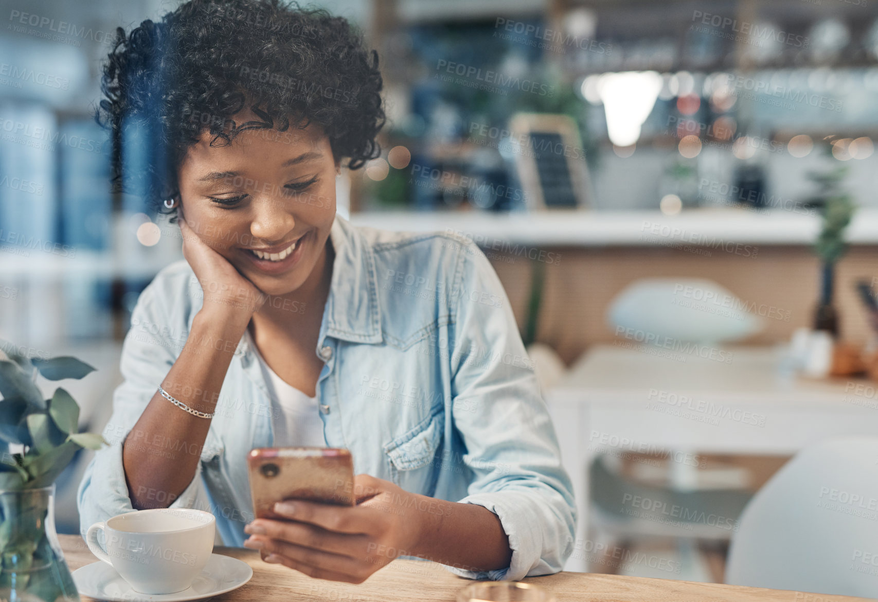 Buy stock photo Cropped shot of a woman using her cellphone while sitting in a cafe