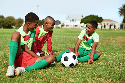 Buy stock photo Shot of a group of young boys taking a break while playing soccer on a sports field