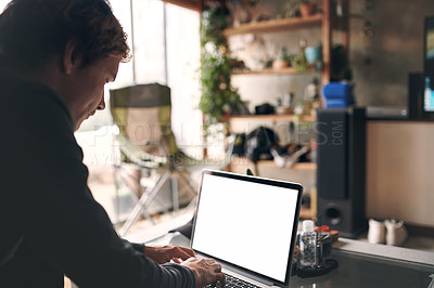 Buy stock photo Shot of a young man using a laptop at home