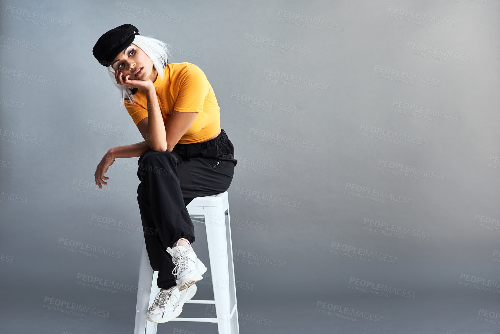 Buy stock photo Woman, chair and fashion in studio with hat for confidence, thinking and style ideas in mockup. Model girl, stool and streetwear clothes with newsboy cap, thoughts and space by gray background