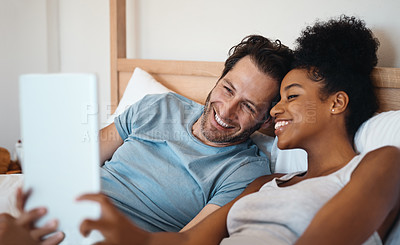 Buy stock photo Happy couple, smile and relax on bed for selfie, photo or morning post together at home. Interracial man and woman person smiling for fun profile picture, memory or vlog in bedroom at the house