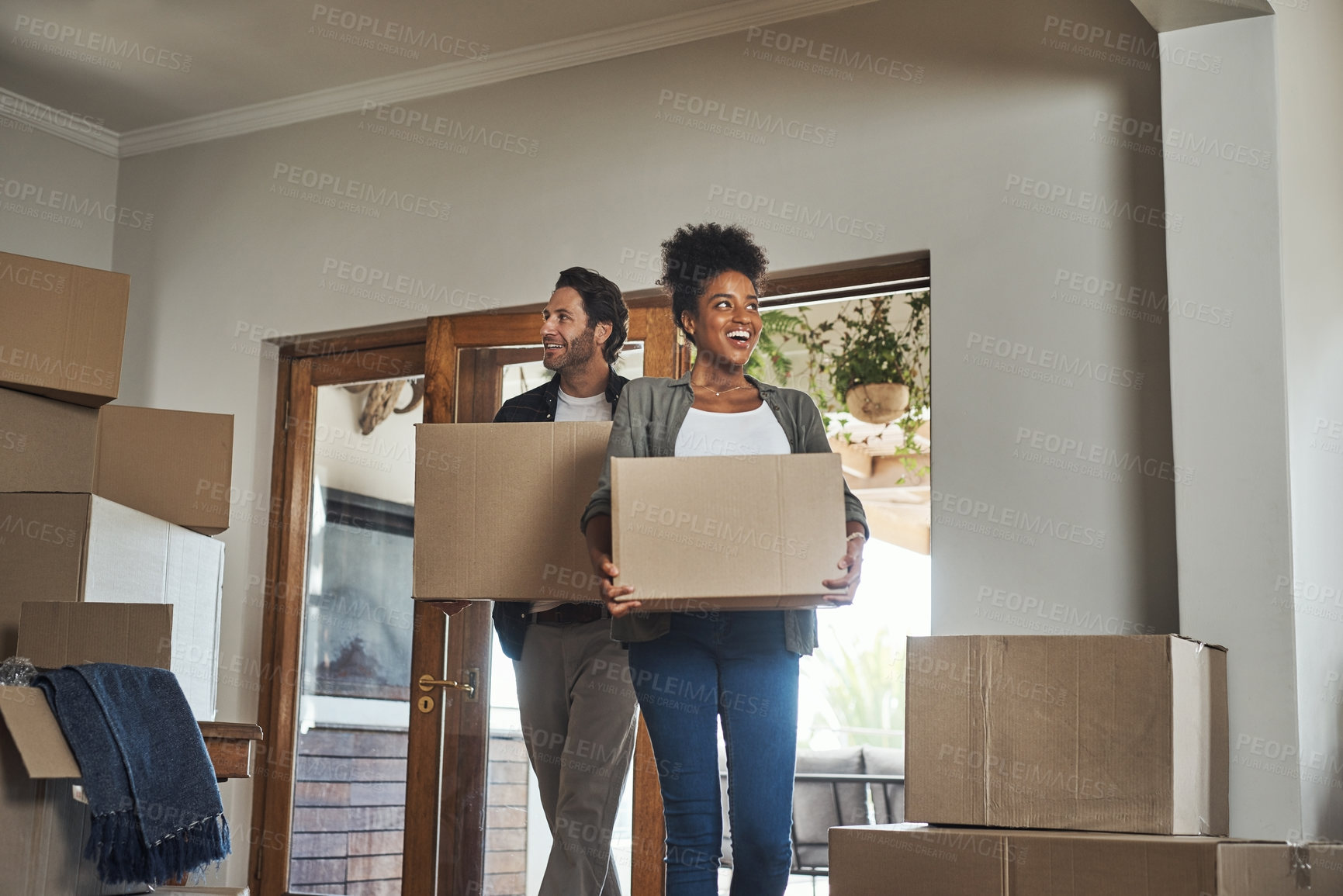 Buy stock photo Happy couple, real estate and boxes in new home for renovation, investment or relocation together. Interracial man and woman real estate owner carrying box in house, move or mortgage for property