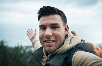 Buy stock photo Shot of a young man taking selfies while out on a hike