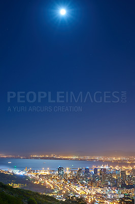 Buy stock photo Urban city lights with a full moon in the midnight sky with copy space. Skyline with colorful lighting with the wide open ocean on the horizon. City buildings at night in Signal Hill, South Africa