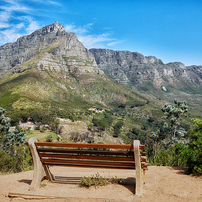 Buy stock photo Wooden bench in a relaxing mountain range in a botanical garden. Table Mountain National park in Cape Town, South Africa with blue sky and local seating to enjoy calm and zen view of mother nature