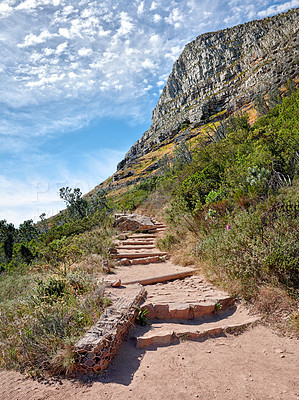 Buy stock photo Scenic hiking trail along Table Mountain in Cape Town, South Africa with lush plants against a cloudy blue sky background. Panoramic of a beautiful and rugged natural landscape to explore and travel