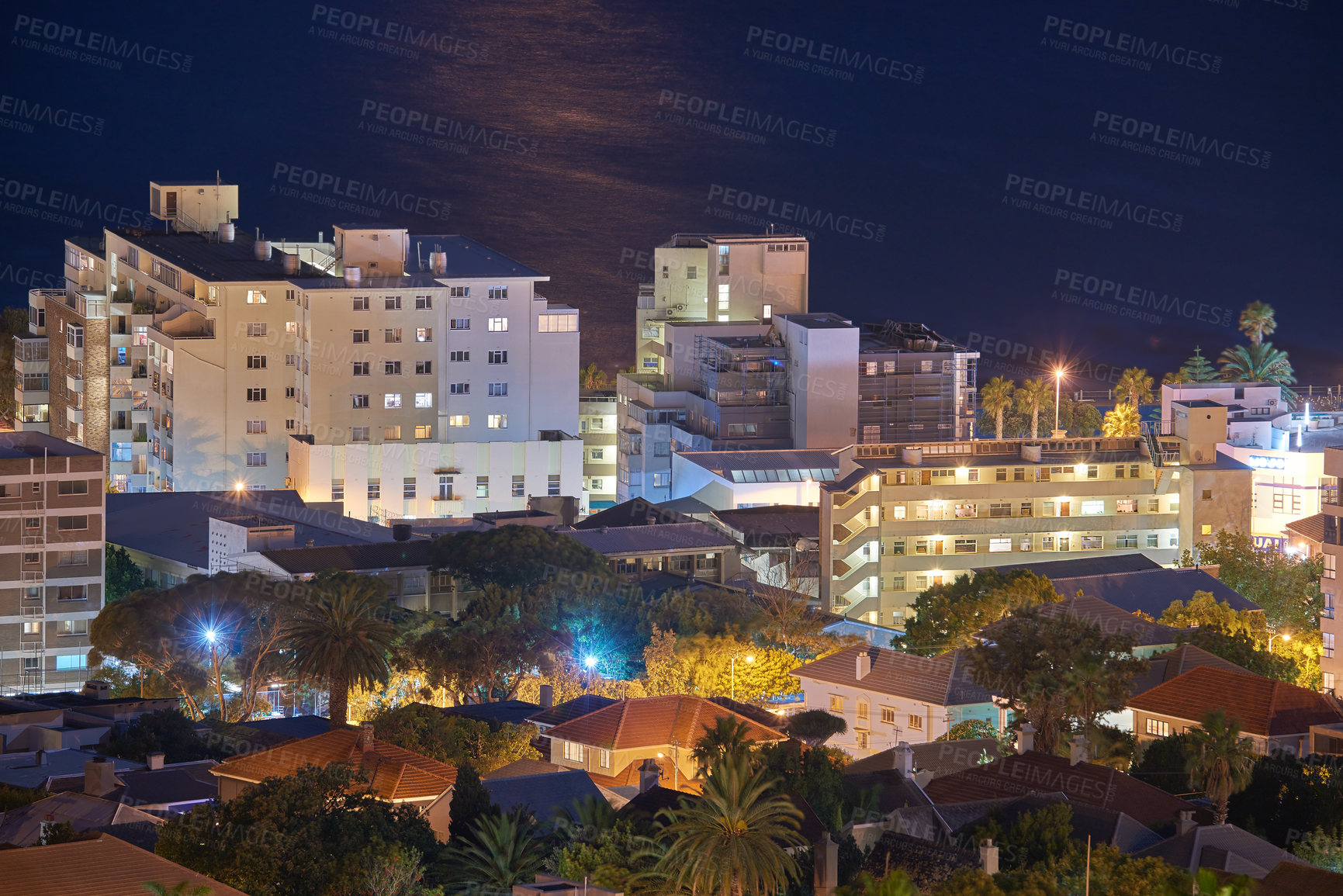 Buy stock photo Night cityscape view of city buildings with electricity lights, infrastructure and sea or ocean background in abroad travel destination. Cape Town, South Africa downtown centre and urban architecture