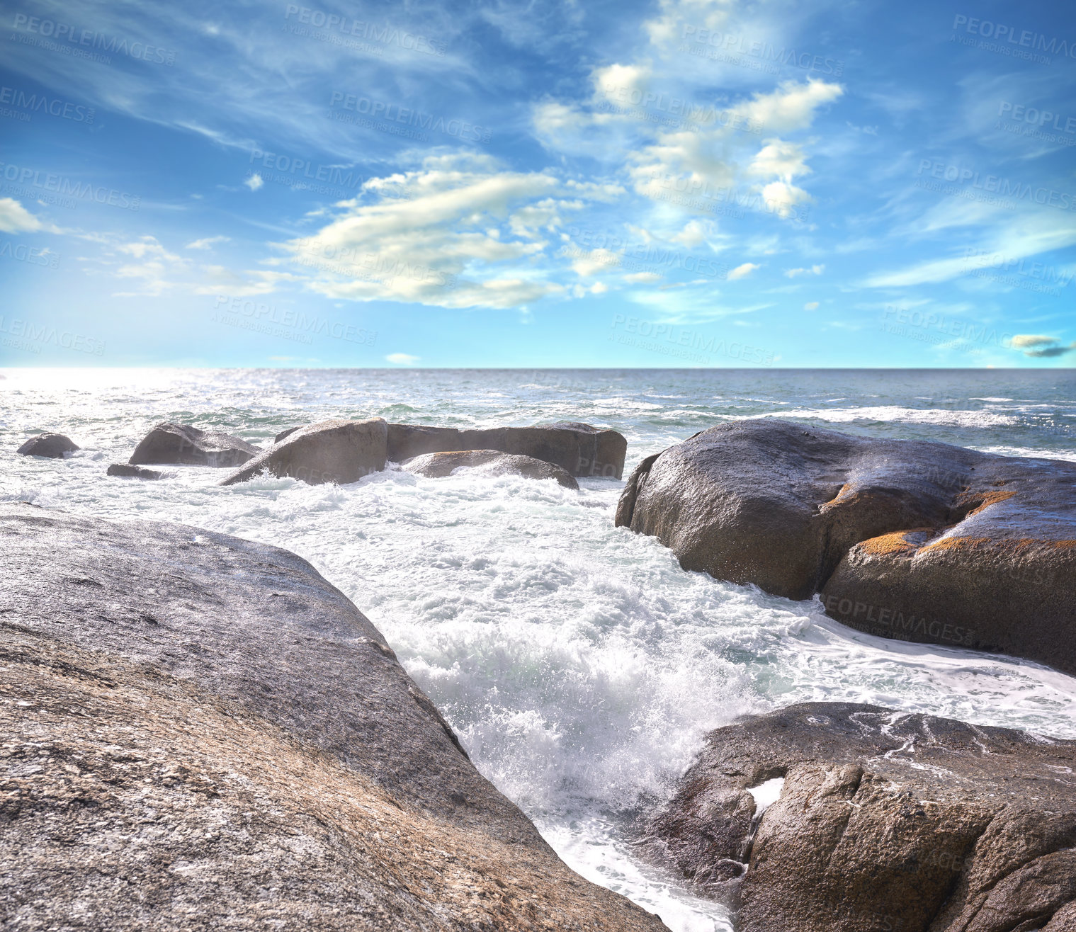 Buy stock photo Copy space ocean view of beach with foamy sea water crashing onto boulders and rocks on a peaceful summer vacation in South African. Texture and detail of scenic coastline and cloudy blue sky