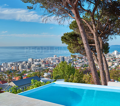 Buy stock photo A blue pool on a luxury property with a coastal view of Cape Town and tourist landscape. The ocean and city against a clear sky horizon. A popular travel destination for tourists in South Africa 