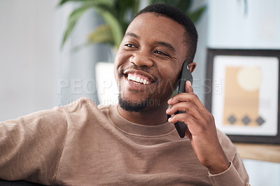 Buy stock photo Black man, phone call and relax in home, house and living room, mobile communication and contact social network. Happy young african guy talking on smartphone, conversation and cellphone technology 