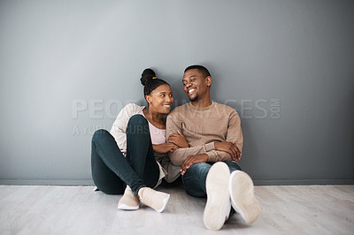 Buy stock photo Homeowner, love and beginning with a black couple sitting together in their new home on a gray wall background. Real estate, room and mortgage with a man and woman on the floor after moving house