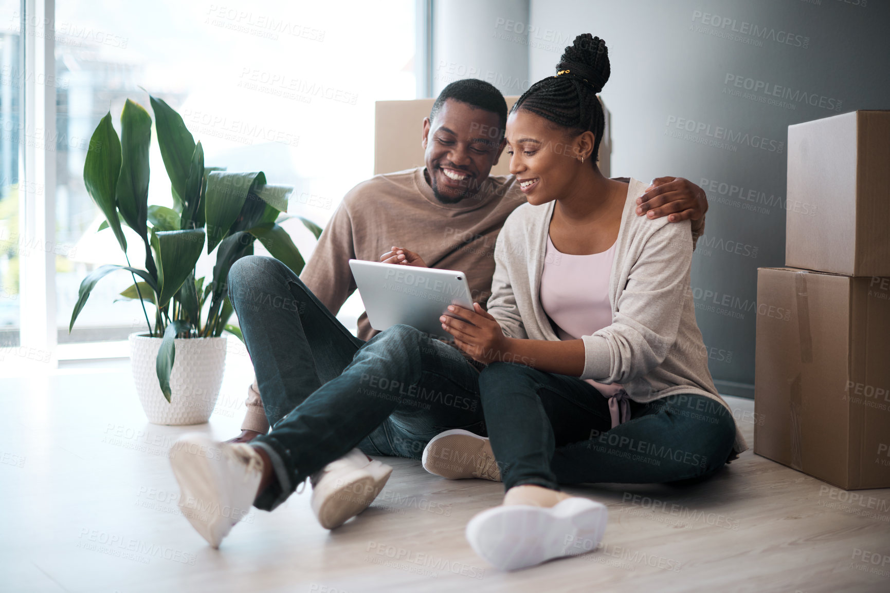 Buy stock photo African couple, real estate and tablet for new house interior shopping, property or relax on floor with boxes. Realtor, happy online communication and homeowners moving or packing apartment together