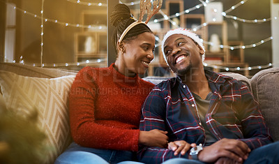 Buy stock photo Couple, living room and Christmas love of a celebration on a sofa with bonding and care. Black people smile in a house for holiday to celebrate winter happiness together with partner and funny hats