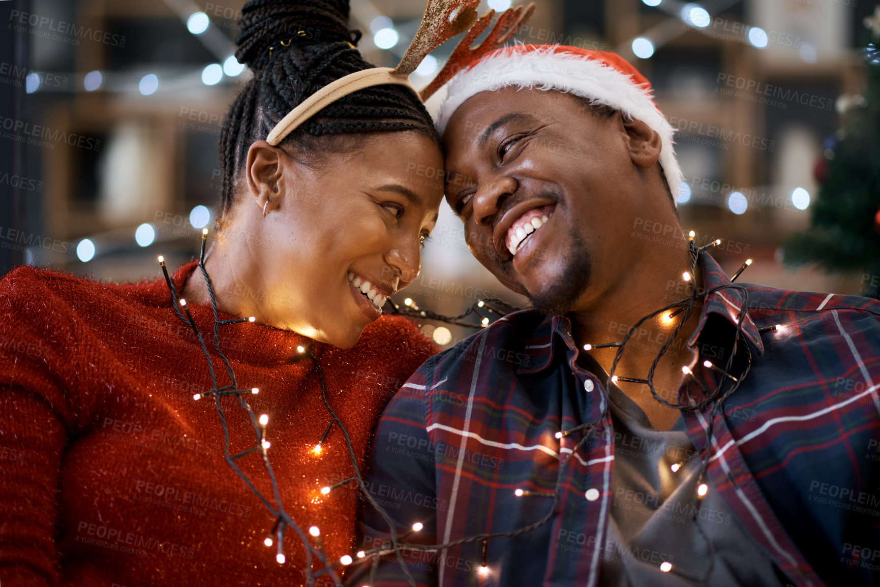 Buy stock photo Couple, christmas celebration and festive holiday, lights and happy smile, hat and love together with home decoration. Black man, woman or happiness for xmas in house, celebrate or enjoy with partner