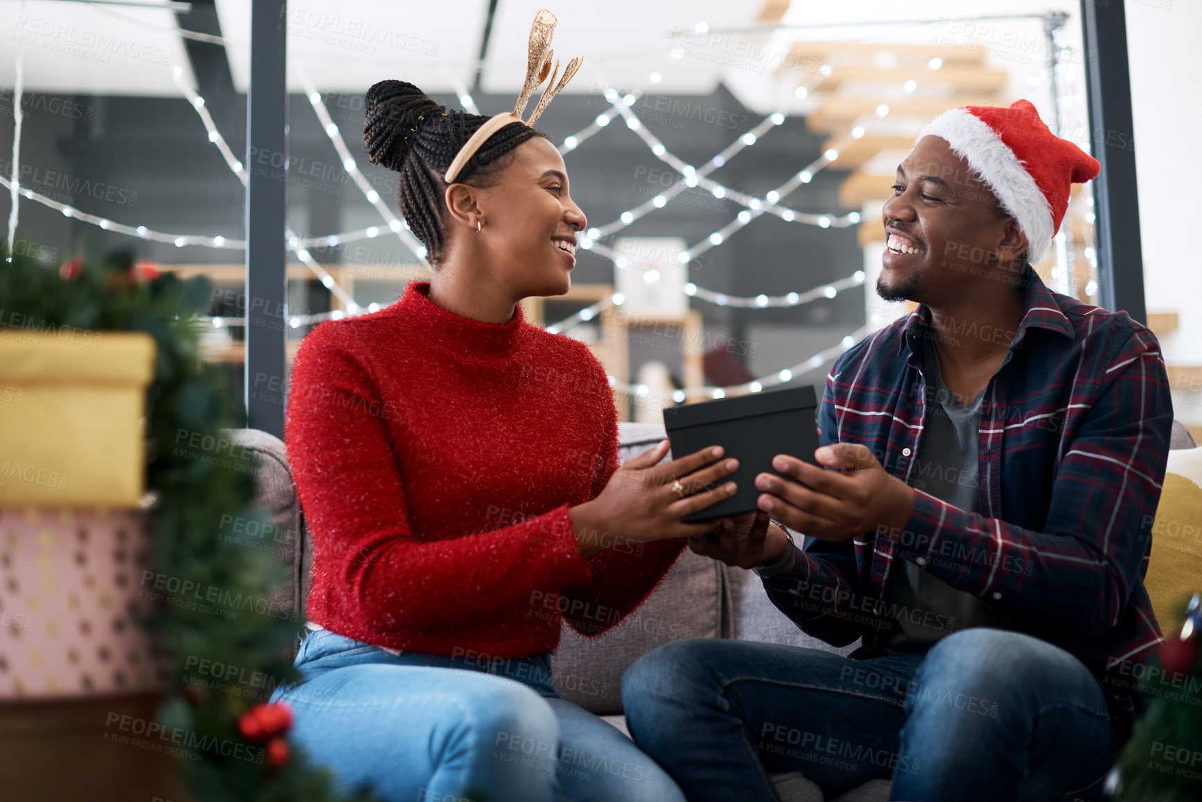 Buy stock photo Gift, couple and christmas celebration on sofa by happy, excited and loving people sharing joy, cheer and giving in their home. black couple, box and gift exchange in a living room, festive and xmas