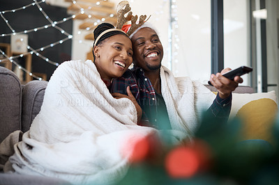 Buy stock photo Christmas, comfort and African couple watching tv, news or a movie from the living room sofa. Television, relax and black man and woman on the couch for a film on a subscription service for festive