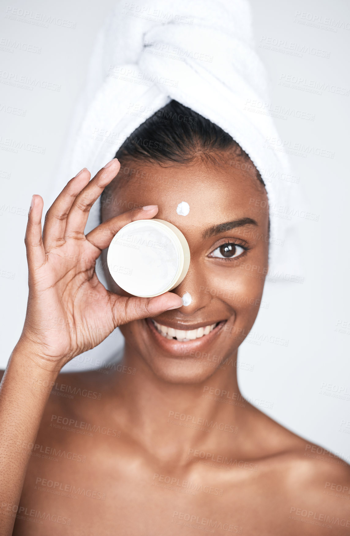 Buy stock photo Cropped shot of a young woman holding a tub of moisturiser