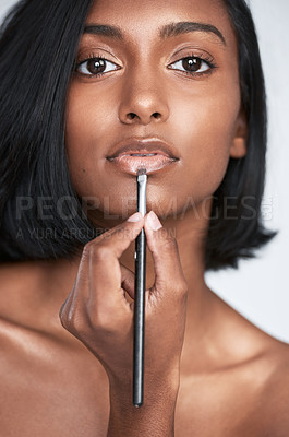 Buy stock photo Cropped shot of a beautiful young woman applying lipgloss to her lips