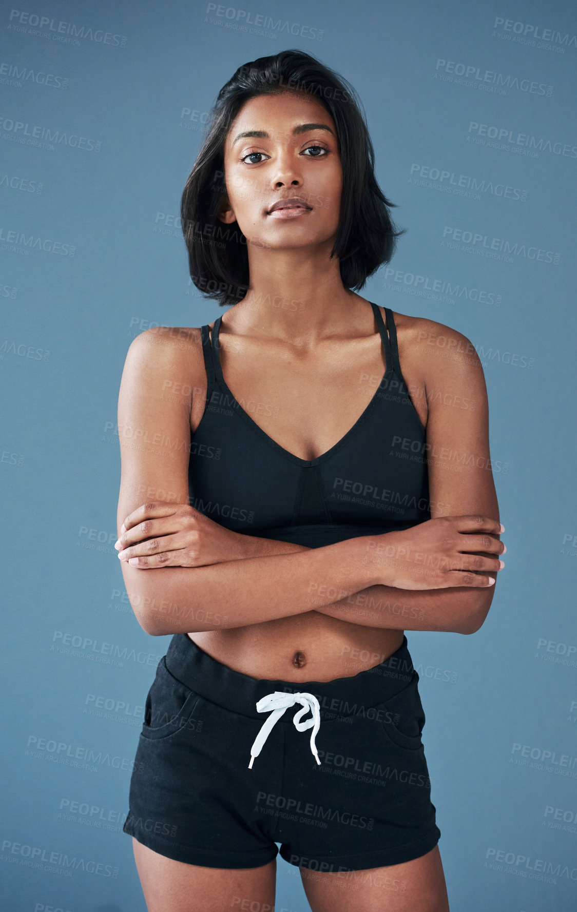 Buy stock photo Shot of a sporty young woman posing against a blue background