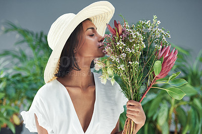 Buy stock photo Cropped shot of a beautiful young woman smelling a bouquet of flowers