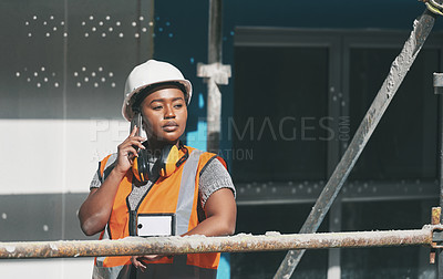 Buy stock photo Construction worker talking on a phone call while standing in a building site. Professional builder discussing plans and strategy, checking the inside structure. Civil engineer doing a safety check