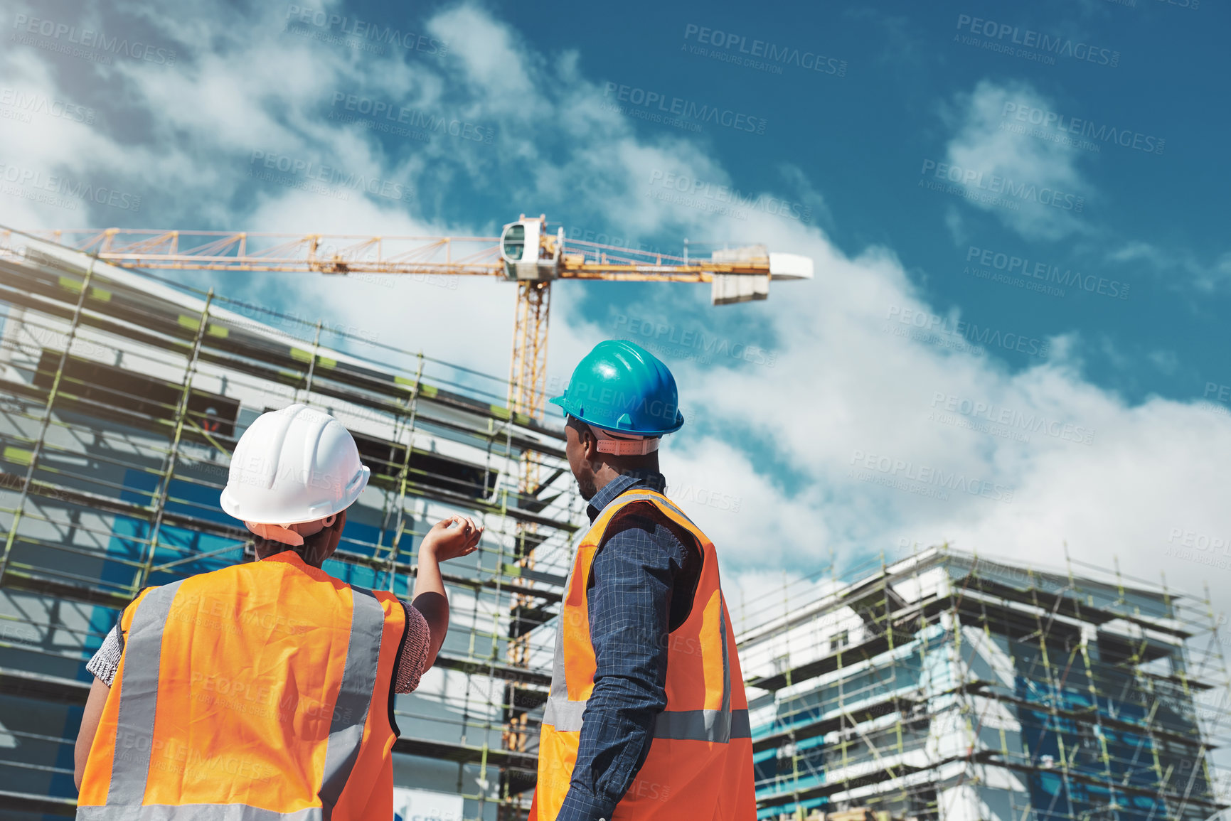 Buy stock photo Shot of a young man and woman assessing progress of the building at a construction site