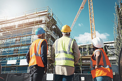 Buy stock photo Shot of a group of builders assessing progress at a construction site