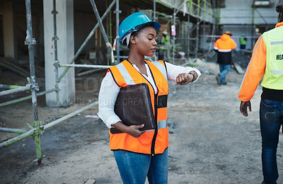 Buy stock photo Shot of a young woman checking the time while working at a construction site