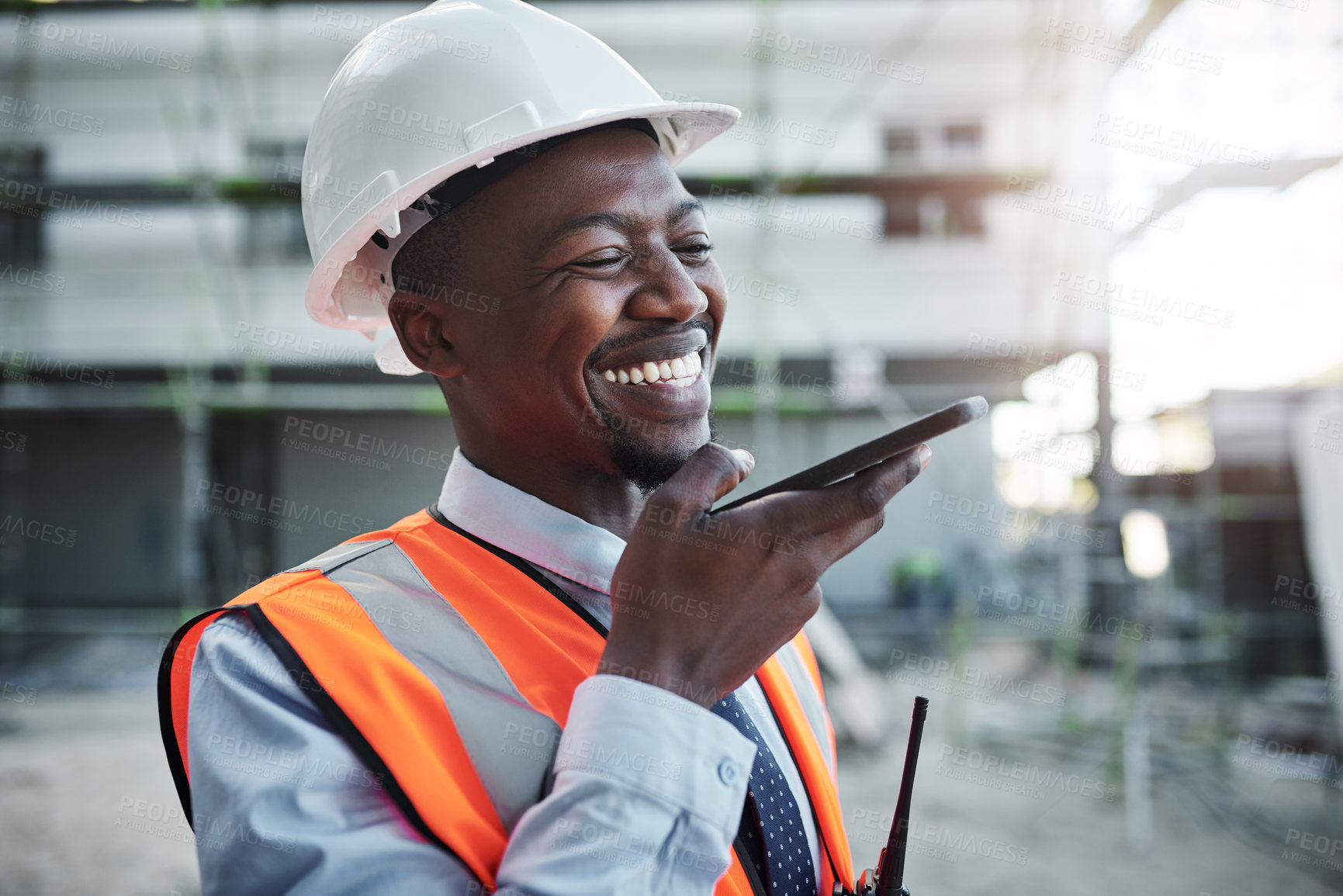 Buy stock photo Happy, black man and architect with speaker phone at site for communication or construction. Young African, civil engineer or builder with smile on mobile smartphone for radio or voice note in city