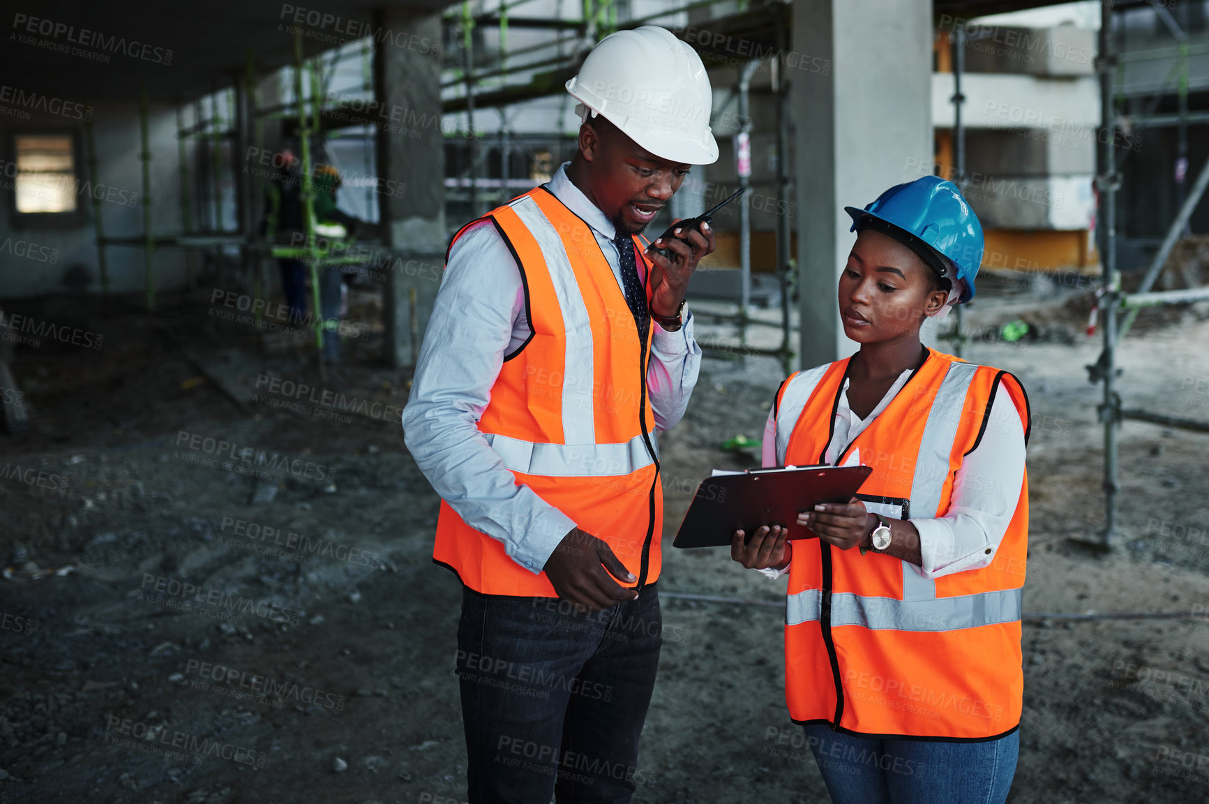 Buy stock photo Shot of a young man and woman having a discussion while working at a construction site