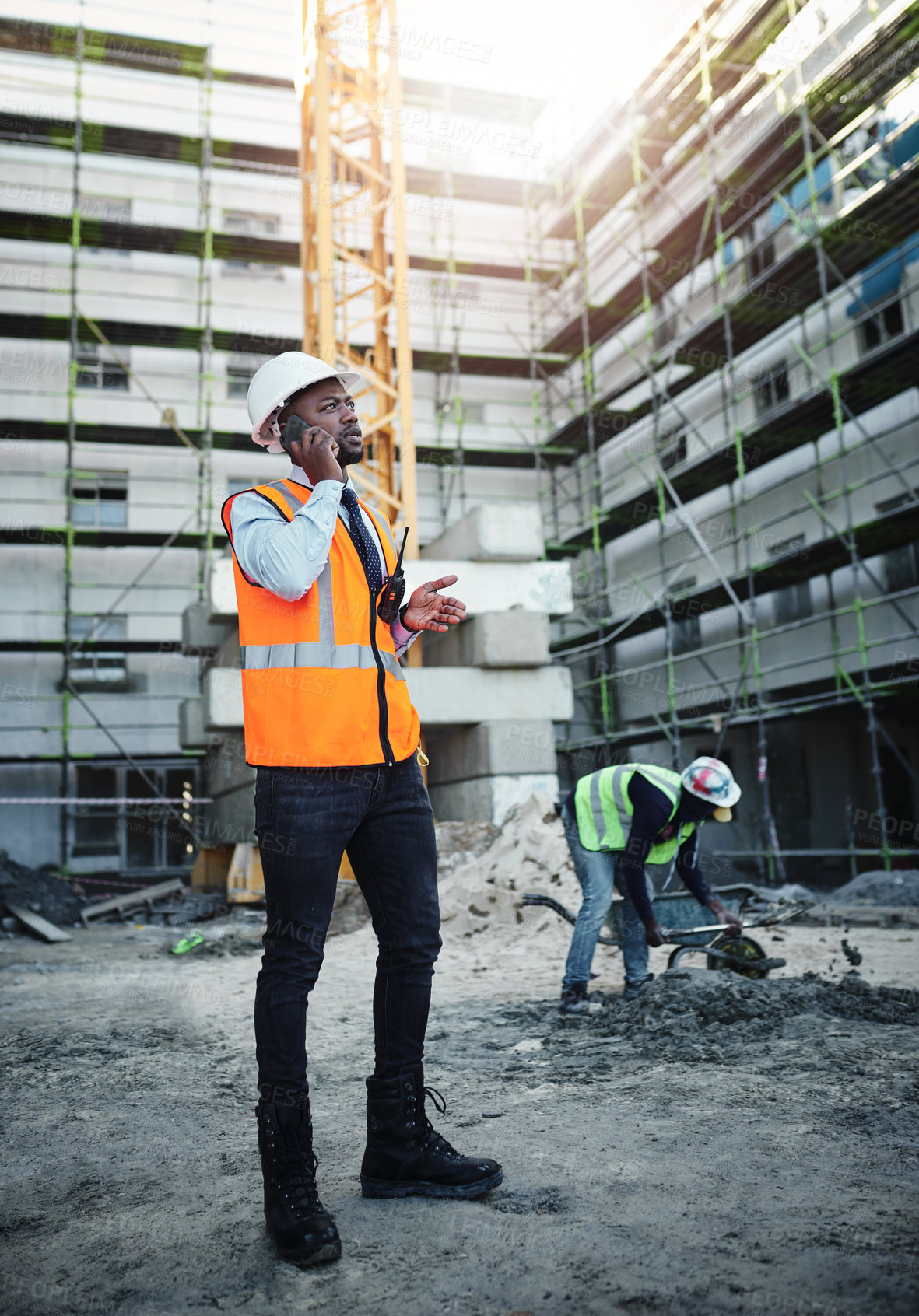 Buy stock photo Black man, civil engineer and talking with phone call on site for communication, construction or maintenance in city. Young African, architect or builder with mobile smartphone for industrial job