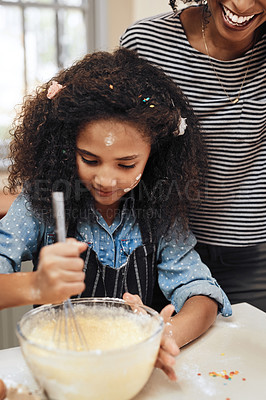Buy stock photo Shot of a little girl baking at home with her mother's help