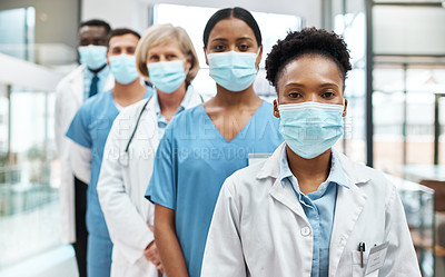 Buy stock photo Portrait of a group of medical practitioners wearing face masks while standing together in a hospital