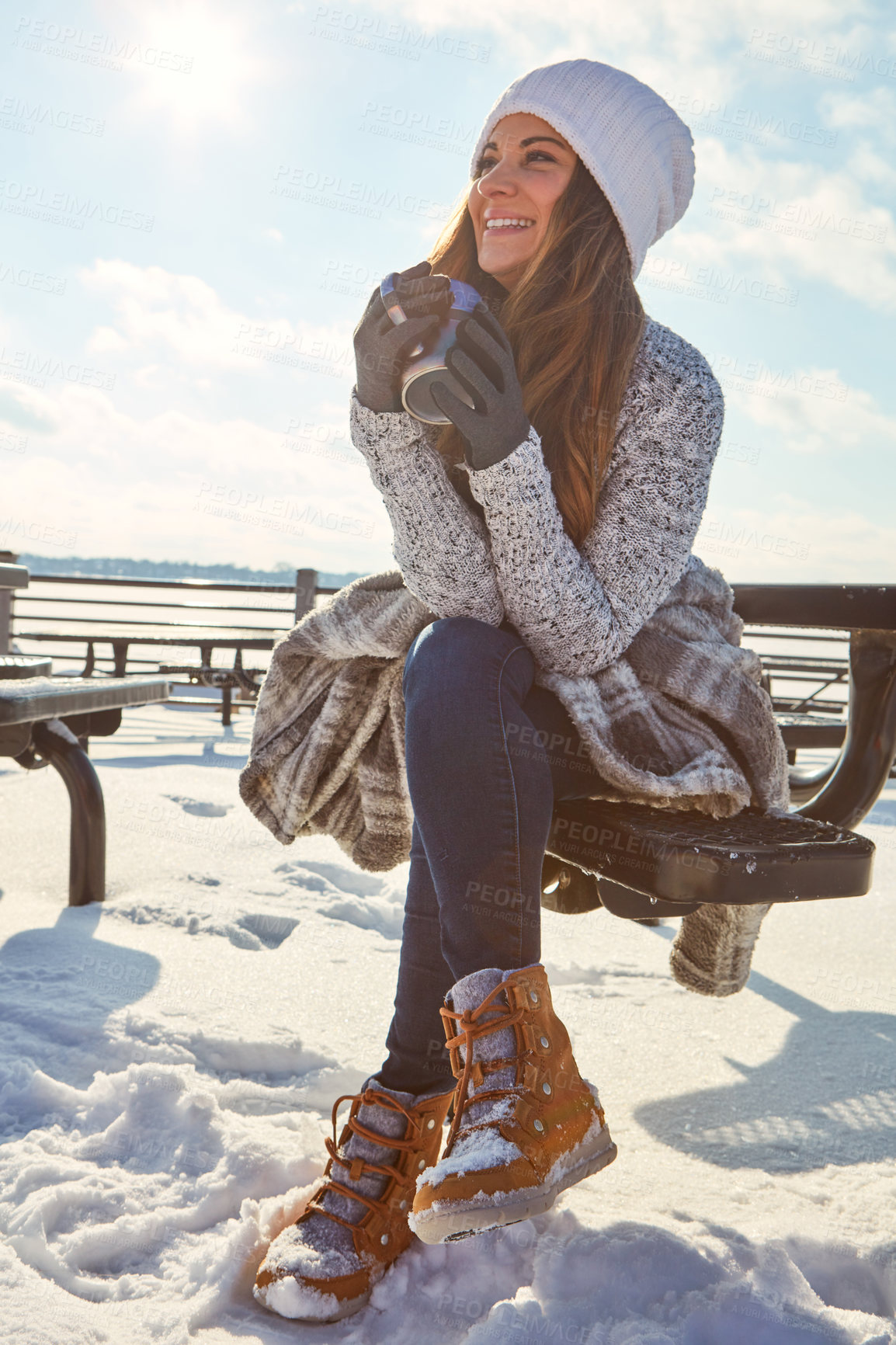 Buy stock photo Shot of a beautiful woman enjoying a hot beverage while sitting outside in the snow