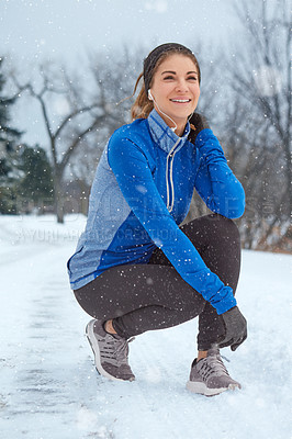 Buy stock photo Shot of a woman taking a break while out for a run on a winter's day