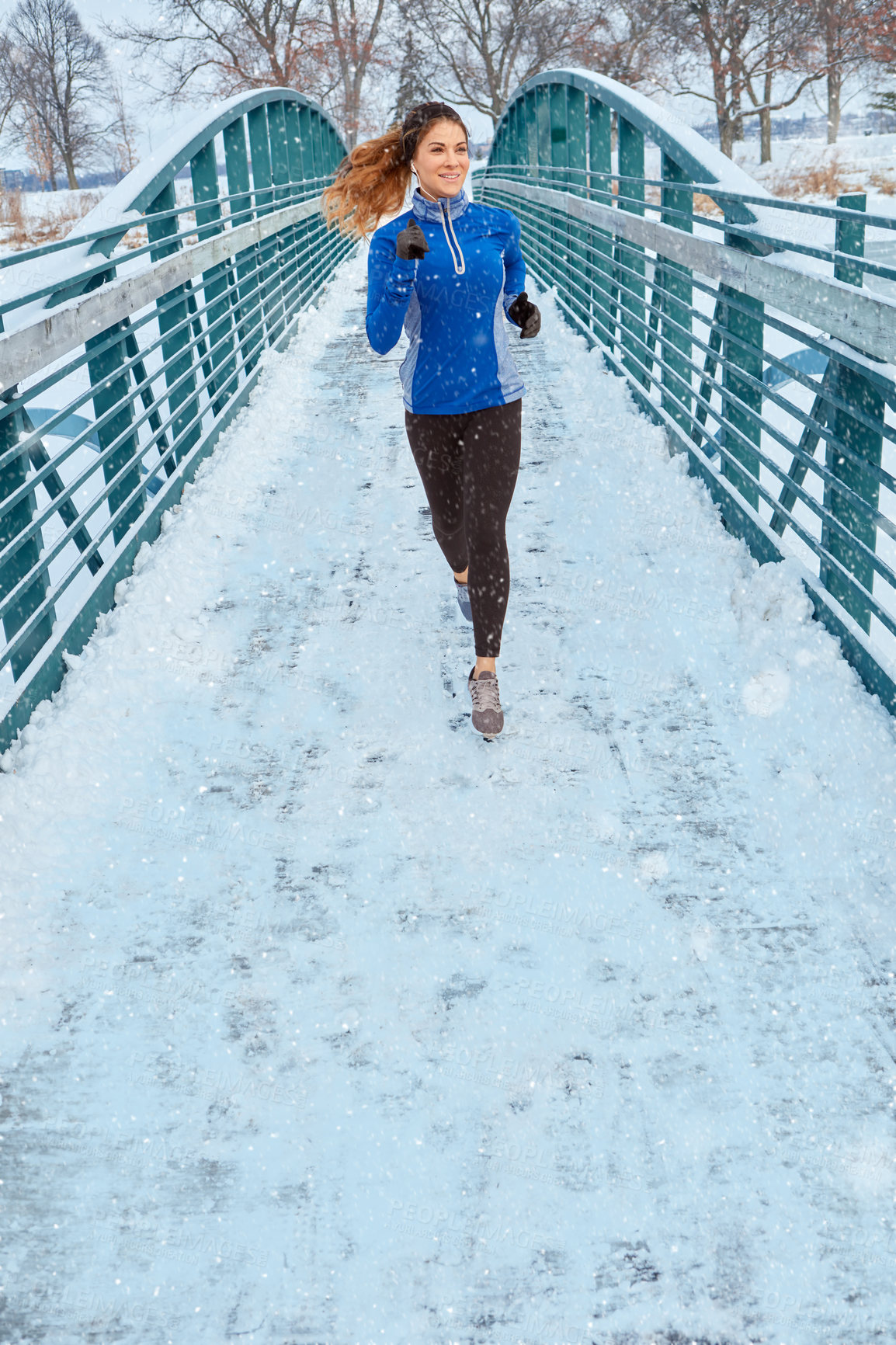 Buy stock photo Shot of a woman wearing warm clothing while out for a run through the snow