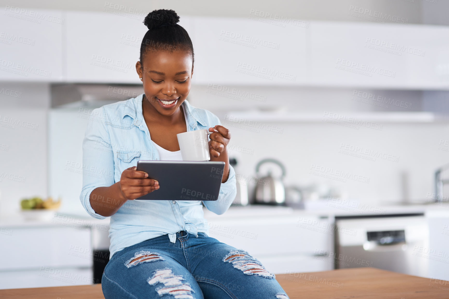 Buy stock photo Shot of a woman drinking coffee while using a digital tablet at home