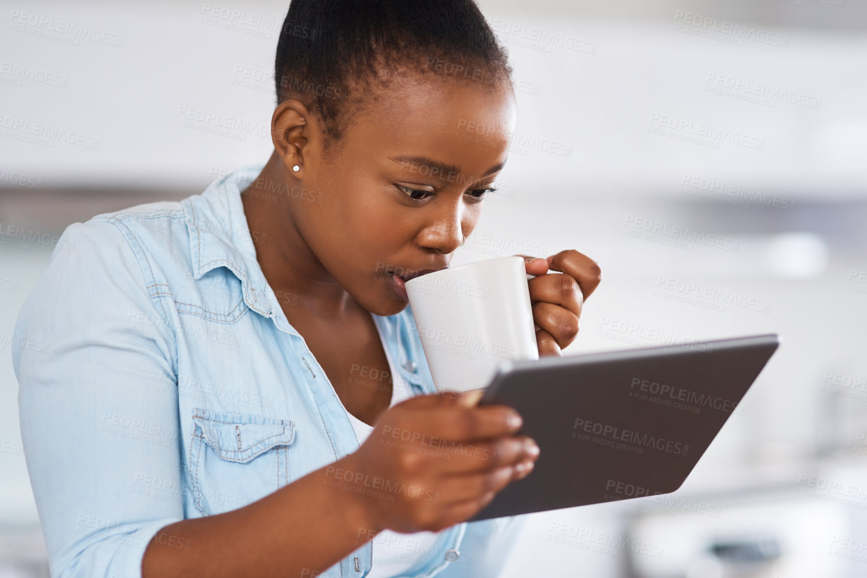 Buy stock photo Shot of a woman drinking coffee while using a digital tablet at home