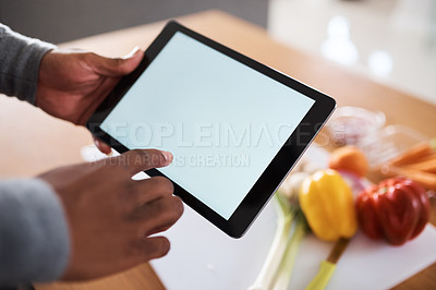 Buy stock photo Shot of an unrecognizable man using a digital tablet while cooking at home