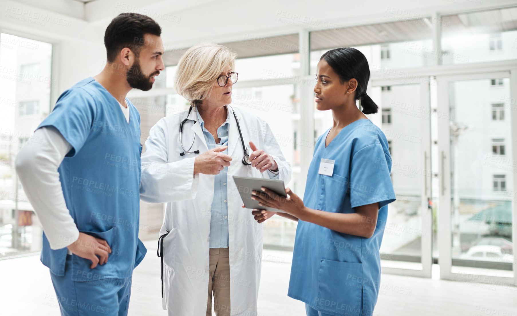 Buy stock photo Shot of a group of medical practitioners having a discussion in a hospital