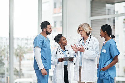 Buy stock photo Shot of a group of medical practitioners having a discussion in a hospital