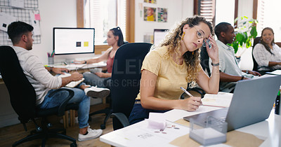Buy stock photo Shot of a young businesswoman looking stressed while using a laptop in a modern office