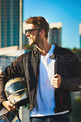 Buy stock photo Shot of a young man riding a motorbike through the city