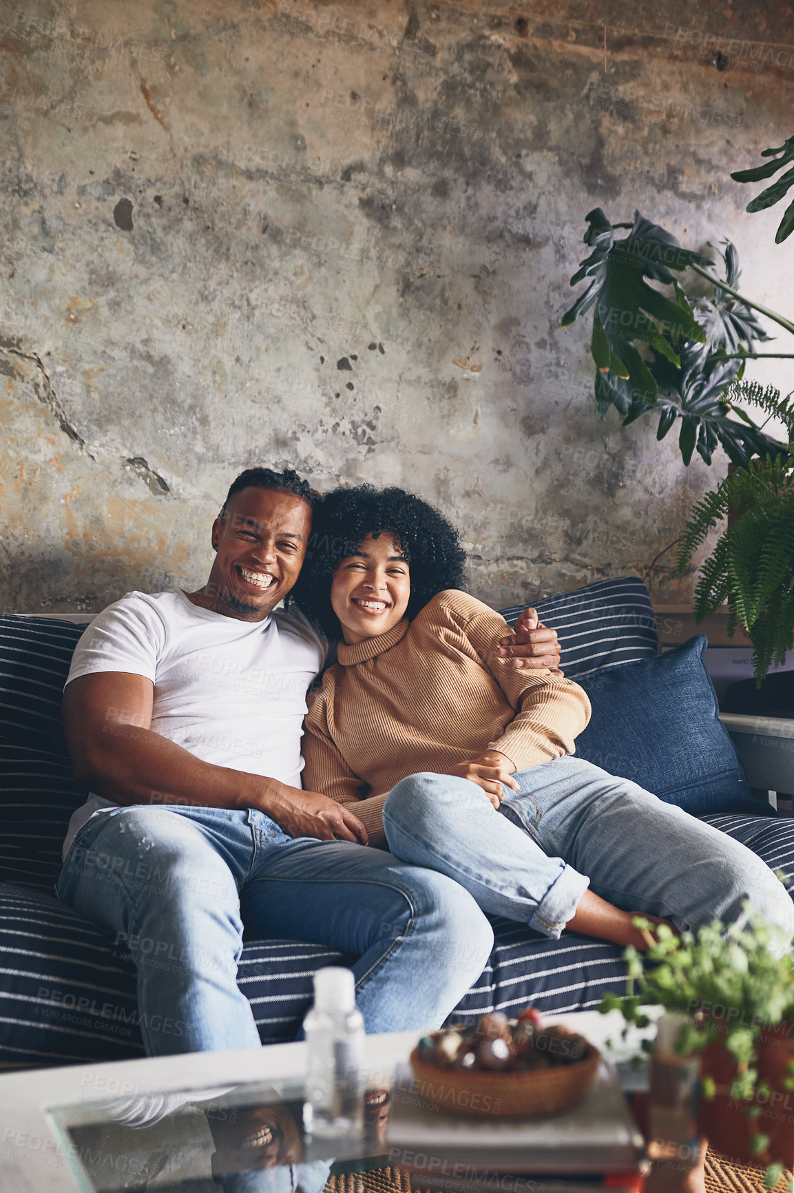 Buy stock photo Portrait of a young couple relaxing together on a sofa at home