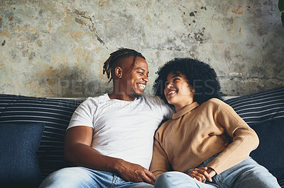 Buy stock photo Shot of a young couple relaxing together on a sofa at home