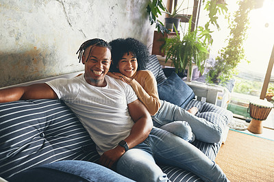 Buy stock photo Portrait of a young couple relaxing together on a sofa at home