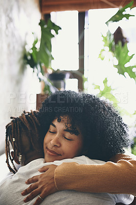 Buy stock photo Shot of a young woman hugging her boyfriend at home